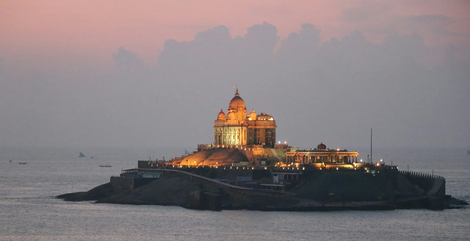 Vivekananda Rock Memorial illuminated against an evening sky in Kanyakumari