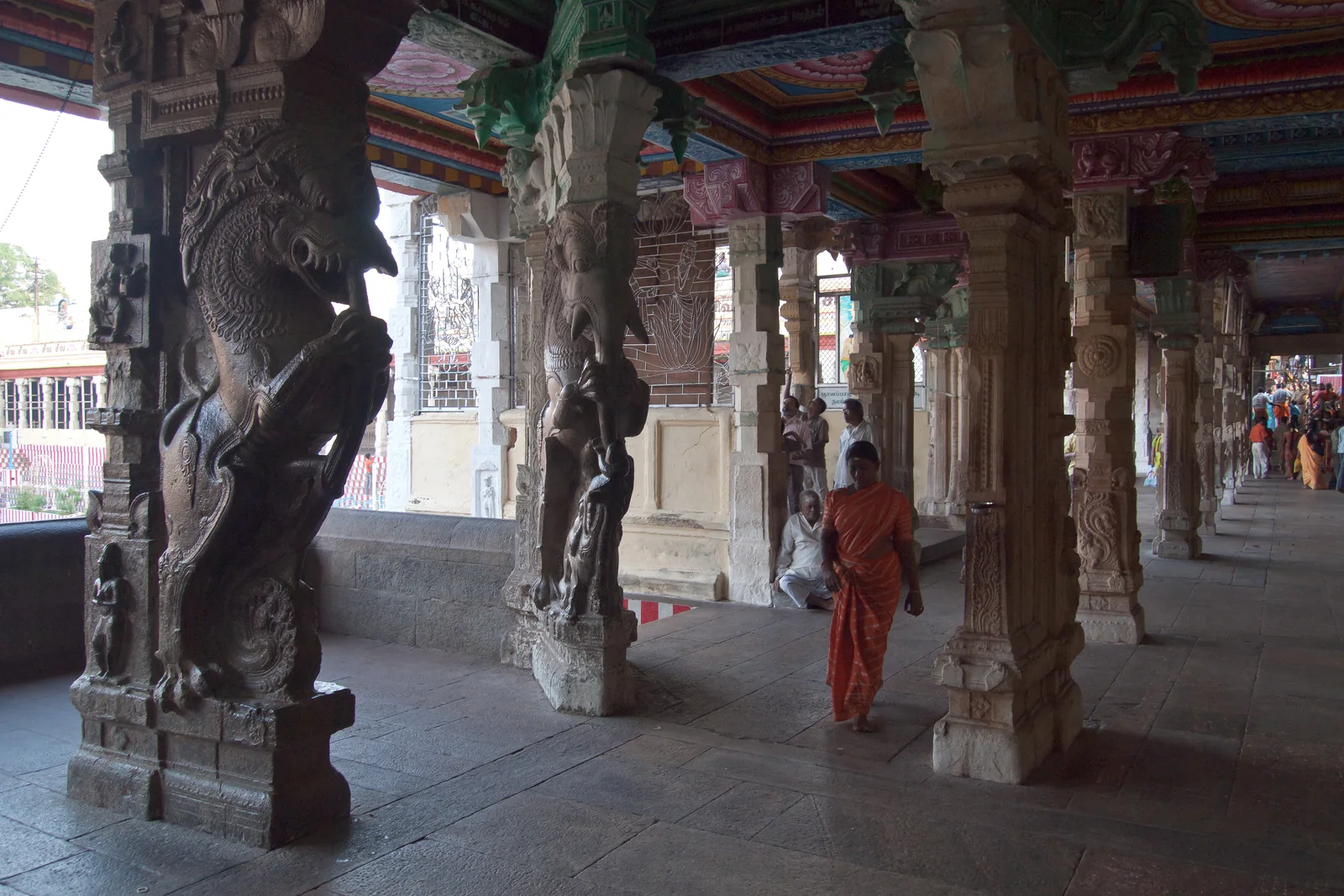 Carved stone pillars and a covered walkway inside the Meenakshi Temple complex